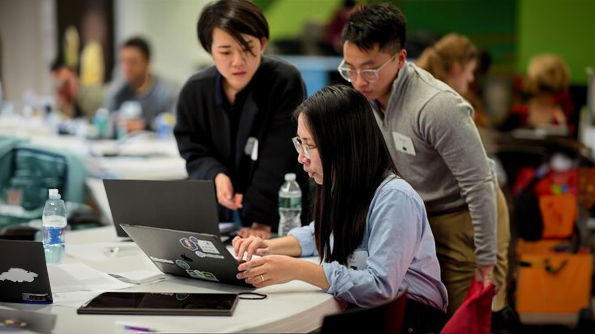 Three of WiDS Datathon participants working on the computer together.