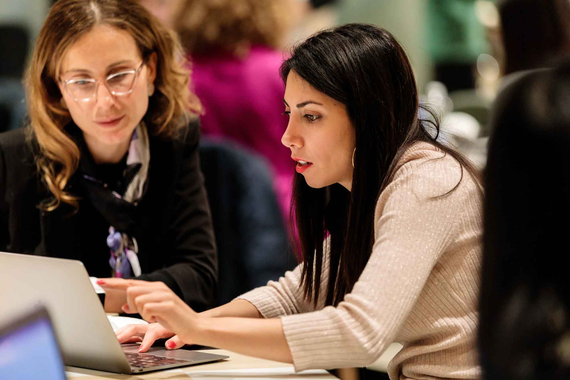 Woman on a computer with instructor next to her