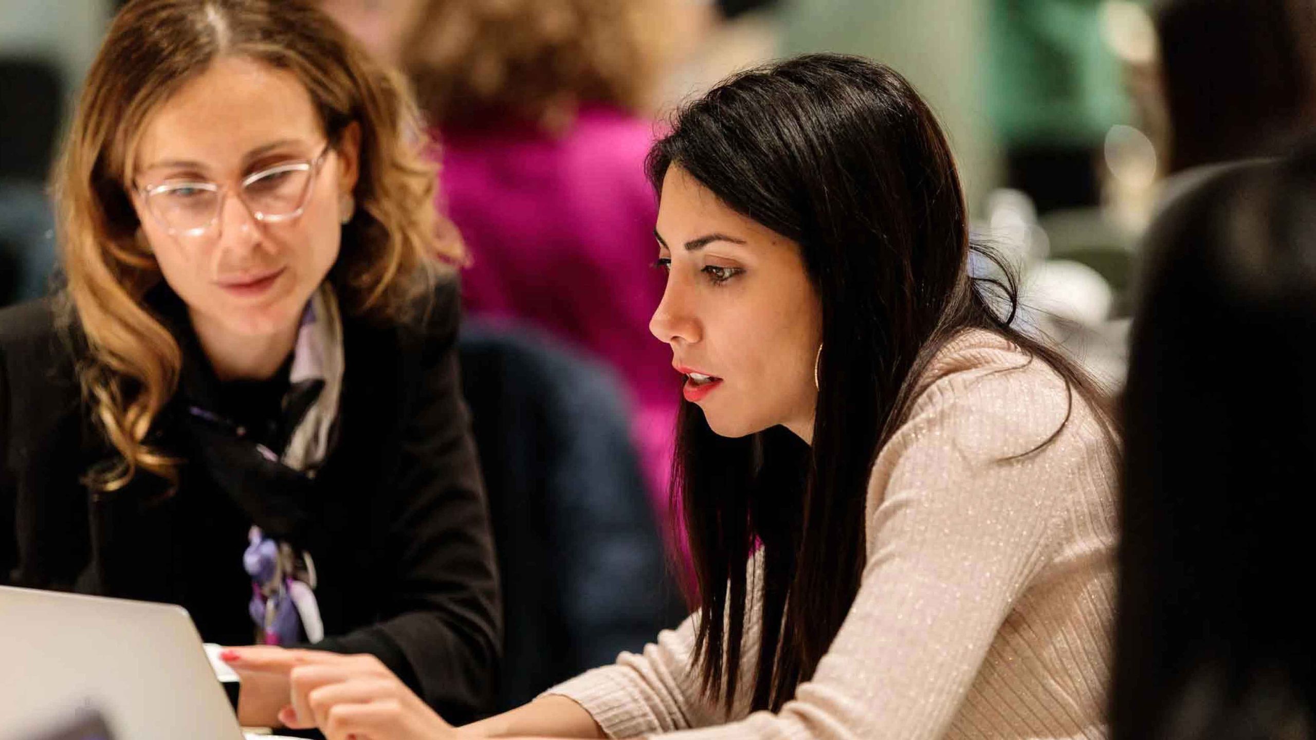 Woman on a computer with instructor next to her