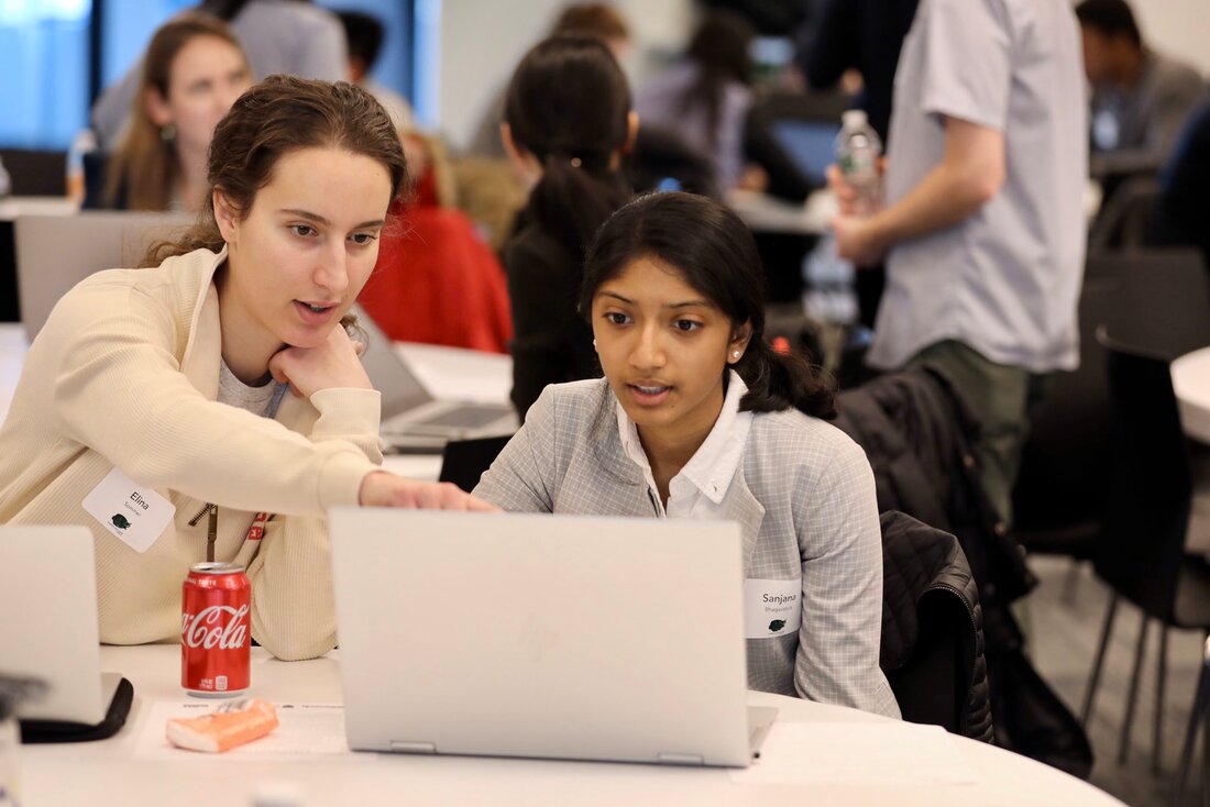 Woman on a computer with instructor next to her